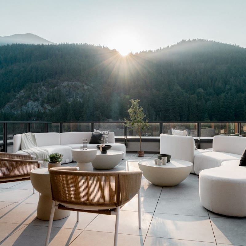 Two Afton Outdoor Lounge Chairs With Palisades Cushion, Natural Cord, And White Frame On a Patio Overlooking a Mountain