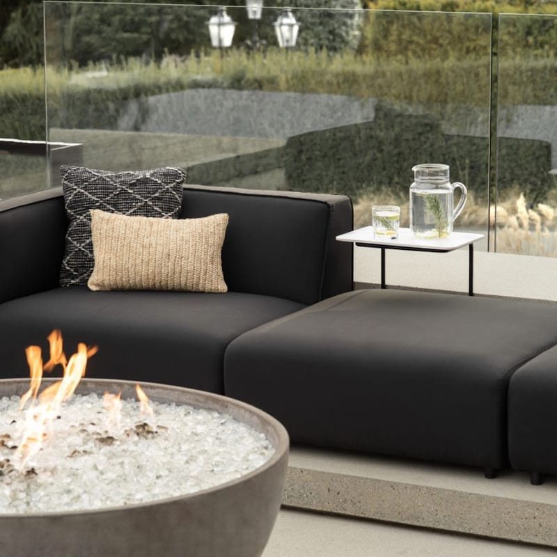Close Up Of The Arya Outdoor Modular Sectional Sofa In Acadia Color Next To Glass Fence In a Backyard