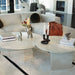 Close Up View of The Romulus Nesting Coffee Table in White Travertine in a Living Room Next to a Sectional Sofa