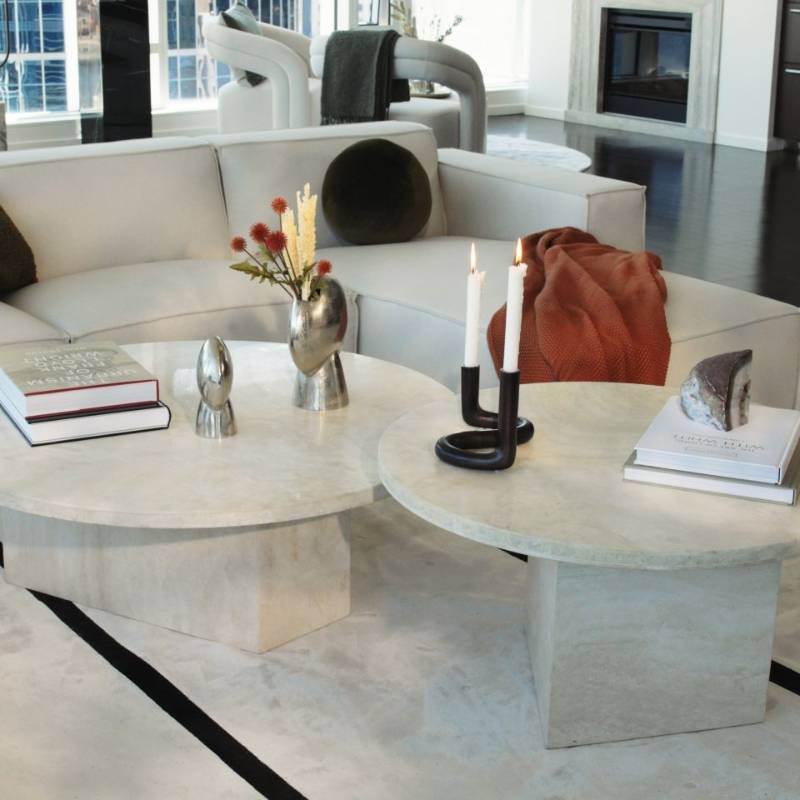 Close Up View of The Romulus Nesting Coffee Table in White Travertine in a Living Room Next to a Sectional Sofa