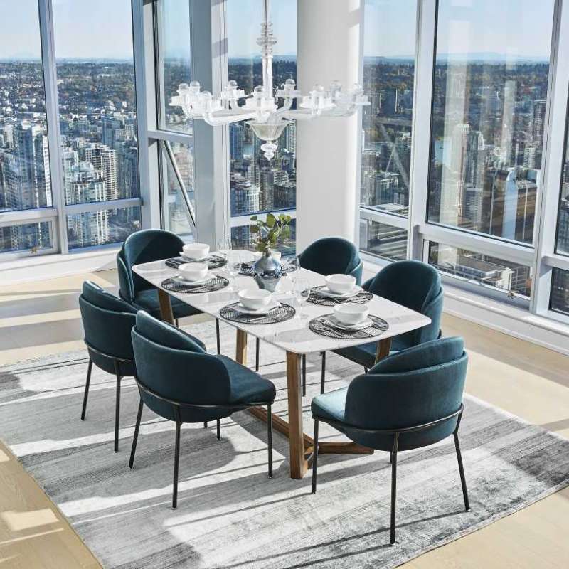 Wide Angled View of The Evelyn Dining Table in White Carrara Marble in The Corner of a Dining Area Overlooking a City View