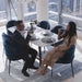 Couple Sitting at the Evelyn Dining Table in White Carrara Marble in The Corner of a Dining Area Overlooking a City View