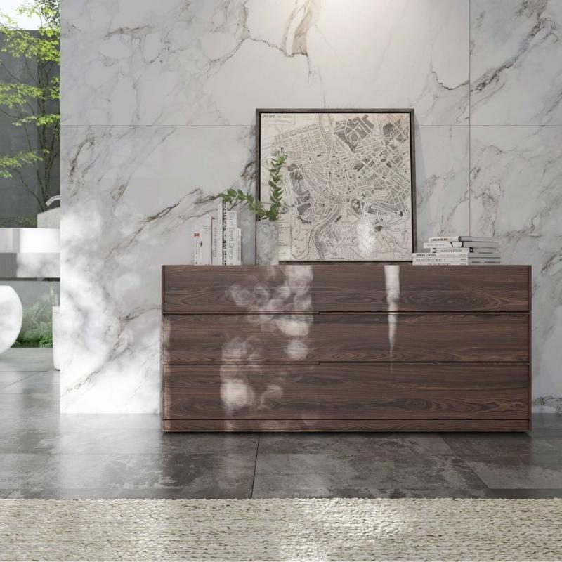 The Hunter Wide Dresser in a Walnut Veneer Finish Next Against a Marble Bedroom Wall